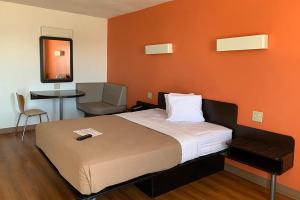 una camera con un letto con una parete arancione di Motel 6 Cameron MO a Cameron