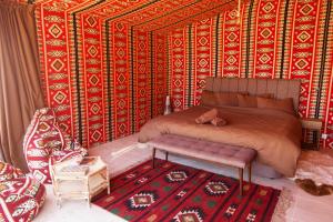 a bed room with a red and white bedspread at Arabian Nights in Wadi Rum