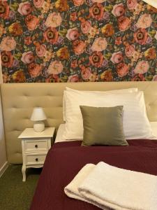 a bedroom with a bed with a floral wallpaper at Penzión Aira in Zvolen