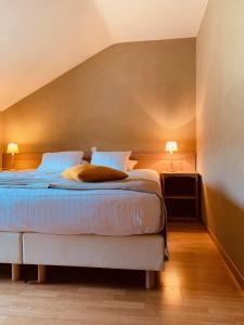 - une chambre avec un lit avec des draps bleus et deux lampes dans l'établissement Hotel La Passerelle, à Grandhan