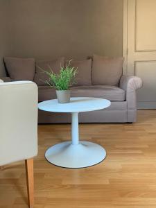 a white coffee table in a living room with a couch at Hotel La Passerelle in Grandhan