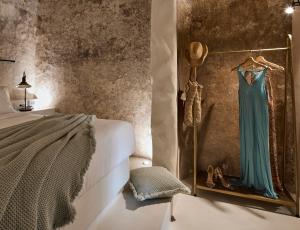 a bedroom with a dress hanging on a wall at Winery Hotel 1870 in Fira