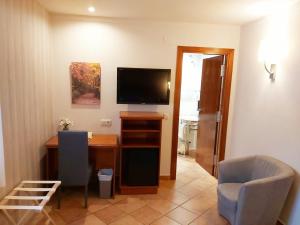 A television and/or entertainment centre at Hotel-Restaurante La Quadra