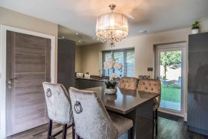 a dining room with a table and chairs and a chandelier at Courtyard Holiday Homes in Southport