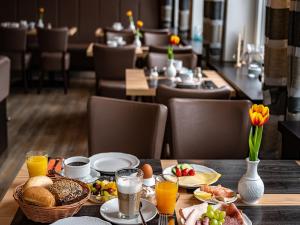 a table topped with breakfast foods and orange juice at Schlei Hotel in Kappeln
