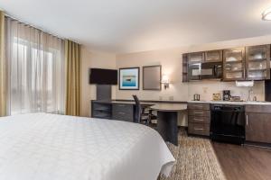 ベンセイラムにあるCandlewood Suites Bensalem - Philadelphia Area, an IHG Hotelのベッドとキッチン付きのホテルルーム