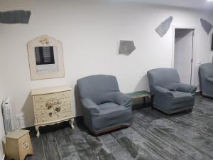 two chairs and a table in a waiting room at Paraiso del Alberche in Navaluenga
