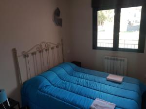 a blue couch in a living room with a window at Paraiso del Alberche in Navaluenga