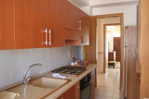 a kitchen with wooden cabinets and a stove top oven at Maison De Lussy in Piazza Armerina