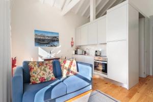uma sala de estar com um sofá azul e uma cozinha em AmaOporto - St. Ildefonso no Porto