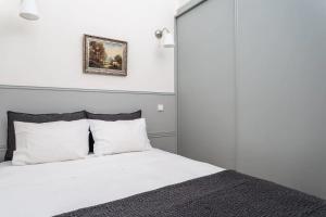 um quarto com uma cama branca e almofadas brancas em AmaOporto - St. Ildefonso em Porto