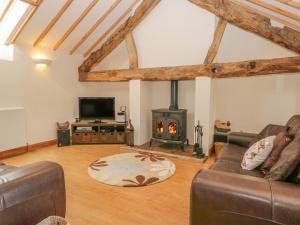 a living room with a fireplace and a couch at Byre Cottage in Great Asby