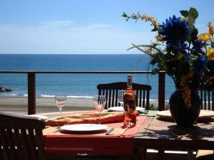 een tafel met een fles wijn en glazen op het strand bij Les Terrasses Du Grand Large Bord de Mer in Palavas-les-Flots