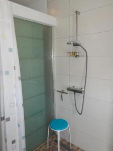 a shower with a blue stool in a bathroom at Neues modern möbliertes Komfortappartement in Hilchenbach