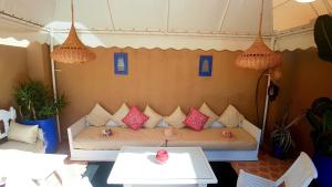 a bed in a tent with pink pillows on it at RIAD AWINATI Location Privatisée ,piscine chauffée in Marrakesh