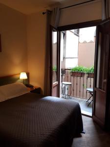 um quarto com uma cama e uma porta para uma varanda em Domus Julia em Roma