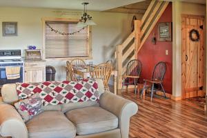 sala de estar con sofá y cocina con mesa en Rural Farmhouse Cabin on 150 Private Wooded Acres!, en Mayville