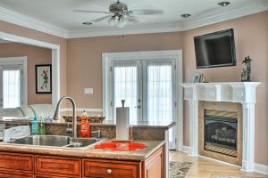 a kitchen with a sink and a fireplace at Waterfront NOLA Villa 23 Mi to French Quarter! in Venetian Isles