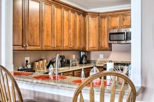 a kitchen with wooden cabinets and a table with chairs at Waterfront NOLA Villa 23 Mi to French Quarter! in Venetian Isles