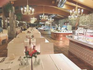 プラヤ・デル・イングレスにあるHotel Parque Tropicalの長いテーブルとシャンデリアのあるレストラン