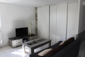 a living room with a couch and a table at Rez de villa avec beau jardin et belle vue in Saint-Laurent-du-Var