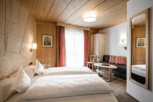 een slaapkamer met een groot bed in een kamer bij Hotel Digon in Ortisei