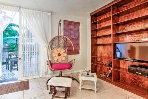 a living room with a chair and a television at Walk to Attractions Tropical Lake Worth Hideaway! in Lake Worth