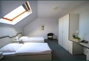 een ziekenhuiskamer met 2 bedden en een raam bij Donatus Hotel in Brauweiler
