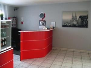 a red counter in a room with a red dresser at Donatus Hotel in Brauweiler