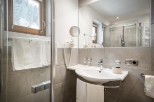 un bagno con lavandino e specchio di Hotel Digon a Ortisei