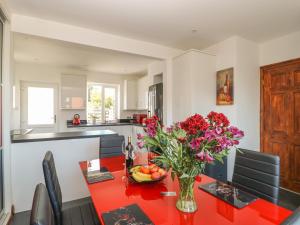 a kitchen with a red table with a vase of flowers at Holmefield House in Ripon