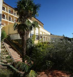 ein Gebäude mit einer Palme davor in der Unterkunft Hotel Grecs in Roses