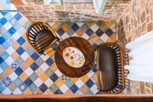 a table with two chairs and a plate on a wall at Palaeopoli Villas in Avlemonas