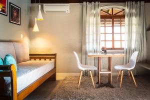 - une chambre avec un lit, une table et des chaises dans l'établissement Hotel Bangalôs da Serra, à Gramado