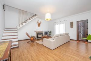 ein Wohnzimmer mit einer weißen Couch und einer Treppe in der Unterkunft Spacious Beach and Golf Villa in Charneca