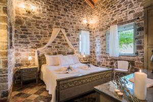 - une chambre avec un lit et un mur en briques dans l'établissement Palaeopoli Villas, à Avlemonas