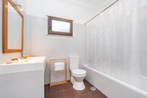 ein Badezimmer mit Toilette, Waschbecken und Badewanne in der Unterkunft Spacious Beach and Golf Villa in Charneca + 22 Fotos