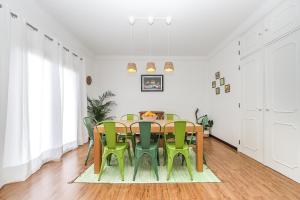 uma sala de jantar com uma mesa e cadeiras verdes em Spacious Beach and Golf Villa em Charneca
