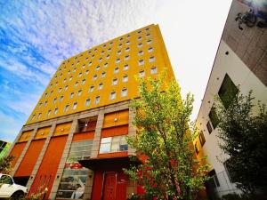 いわき市にあるHotel Frontier Iwaki / Vacation STAY 79266の木の目の前の黄色い建物