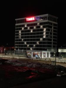 um edifício alto com um letreiro de néon em cima em Grand Times Hotel Drummondville em Drummondville