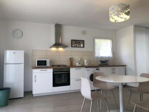 a kitchen with white appliances and a table with chairs at L'Alivu in Ajaccio