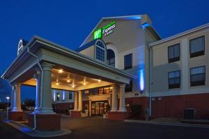 een hotelgebouw met 's nachts een bord bij Holiday Inn Express Hotel & Suites Laurinburg, an IHG Hotel in Laurinburg