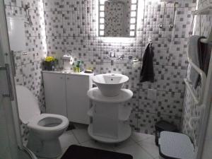 a white bathroom with a toilet and a sink at Apartman Stari most - Old Bridge in Bečej