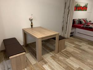 a table and a stool in a room with a bed at Apartmán 206 Špičák in Železná Ruda