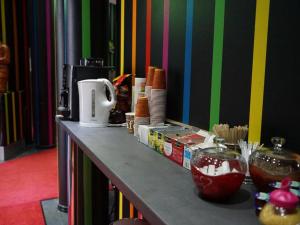a counter top with food and a colorful wall at Amaya Motel in Berlin