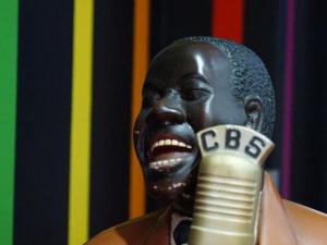 Una statua di un uomo nero che tiene un microfono di Amaya Motel a Berlino