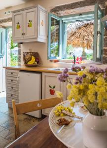 a kitchen with a table with flowers on it at Palaeopoli Villas in Avlemonas