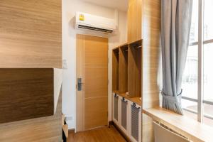 a small room with a door and a window at Atnest Hostel in Bangkok