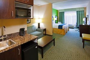 ein Hotelzimmer mit einer Küche und einem Schlafzimmer in der Unterkunft Holiday Inn Express Hotel & Suites Newport South, an IHG Hotel in Newport