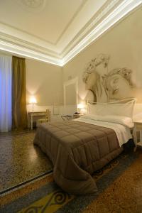 1 dormitorio con 1 cama grande y cabecero grande en Conte di Cavour, en Foggia